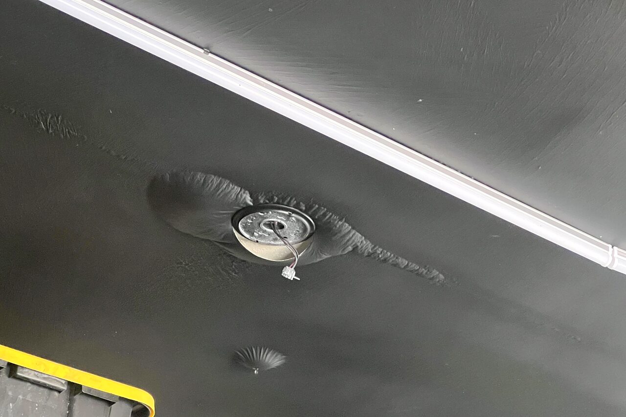 A water stain spreading across a garage ceiling from a hidden leak above