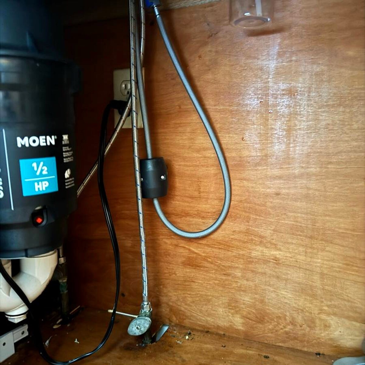 New garbage disposal installed under a sink